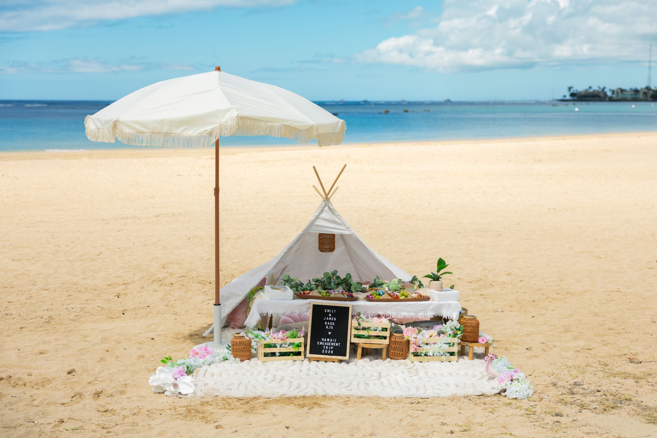 Waterfront teepee picnic setup with fringed umbrella — Oahu Paradise Picnic